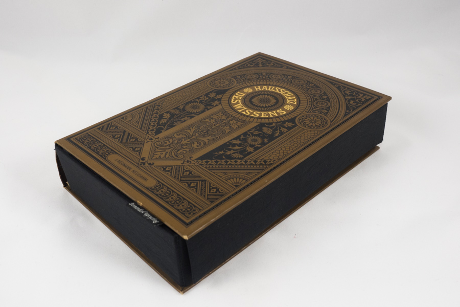 braune Clutch aus dem Buch "Hausschatz des Wissens" mit breiter Verschlusslasche und unsichtbarem Magnet, edel verzierter Bucheinband mit Goldprägungen, kombiniert mit schwarzem Stoff
