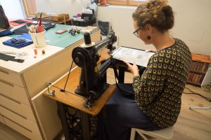 Bernadette Hartl näht auf der 100 Jahre alten Singer Schusternähmaschine mit Fußantrieb