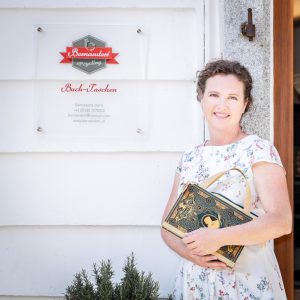 Bernadette Hartl mit einer ihrer Buch-Handtaschen vor ihrem Atelier in Steyr