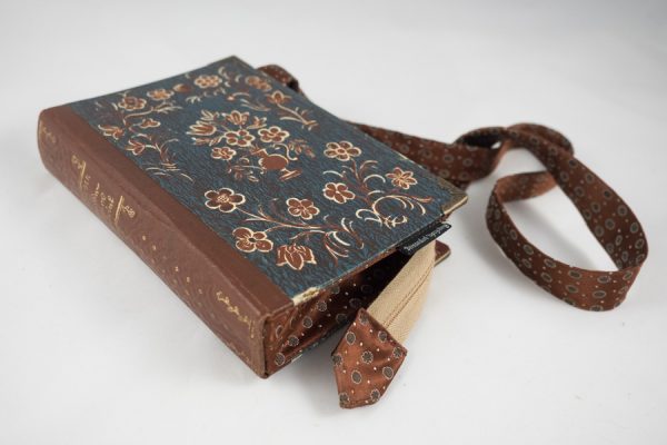 Umhängetäschchen aus einem Buch von Peter Rosegger in mit braunen Blümchen am Cover auf blauem Hintergrund kombiniert mit einer passenden braunen Krawatte