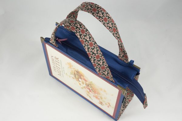 Tasche aus dem Buch "Der lieben Mutter" in blau kombiniert mit einer rosa-blumigen Krawatte, wie Blumen am Cover