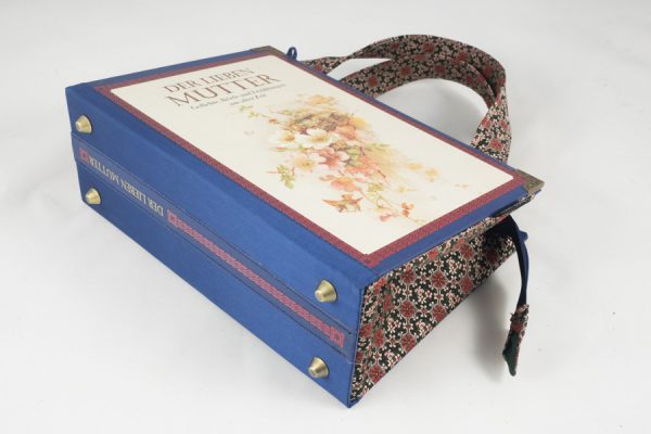 Tasche aus dem Buch "Der lieben Mutter" in blau kombiniert mit einer rosa-blumigen Krawatte, wie Blumen am Cover