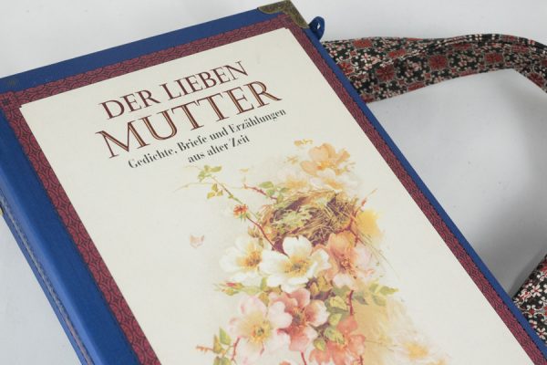 Tasche aus dem Buch "Der lieben Mutter" in blau kombiniert mit einer rosa-blumigen Krawatte, wie Blumen am Cover