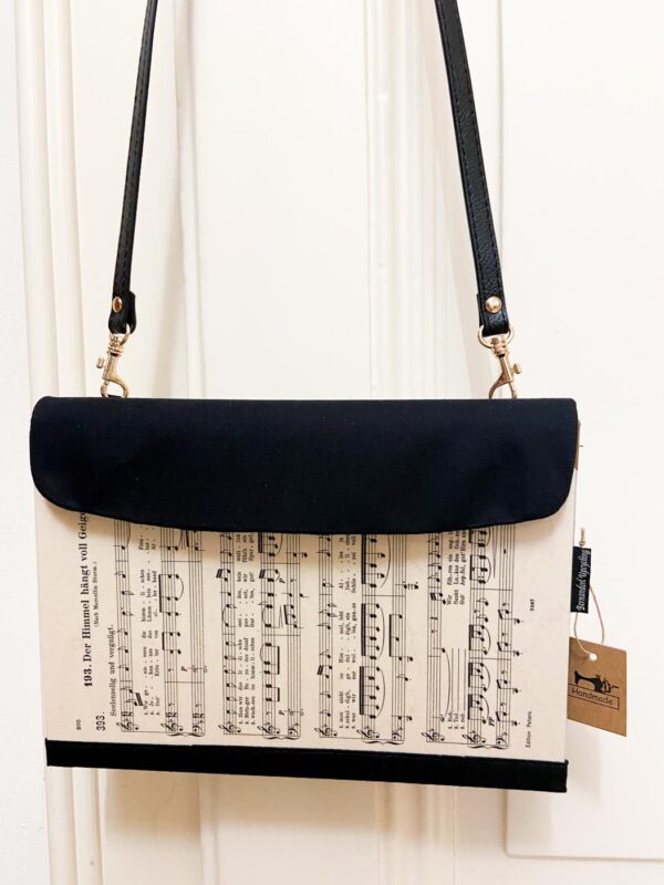 Clutch aus Notenblättern mit schwarzer Lasche als Verschluss