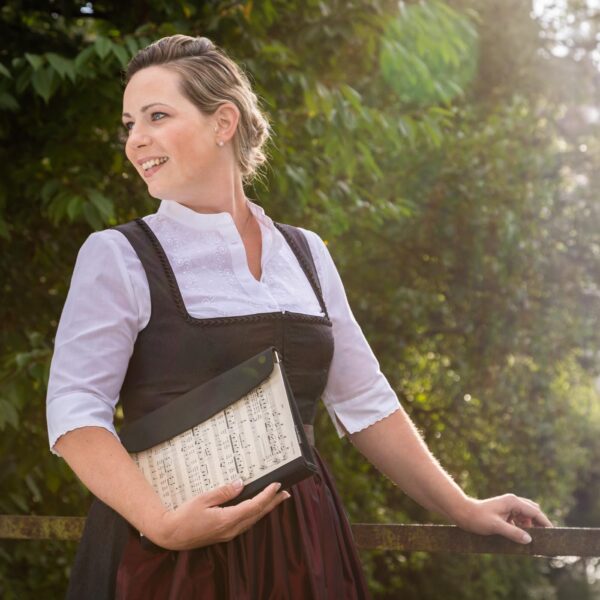 Clutch aus Notenblättern mit schwarzer Lasche als Verschluss