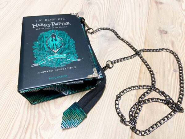 Tasche aus einem Harry Potter Buch in schwarz mit grün und silberner Aufschrift kombiniert mit einer grünen Krawatte