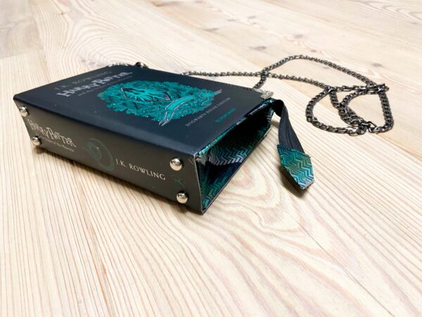 Tasche aus einem Harry Potter Buch in schwarz mit grün und silberner Aufschrift kombiniert mit einer grünen Krawatte