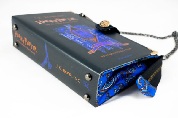 Tasche aus einem Harry Potter buch in schwarz mit blau und Goldschrift kombiniert mit einer blauen Paisley Krawatte und einem Phönix-Zierknopf