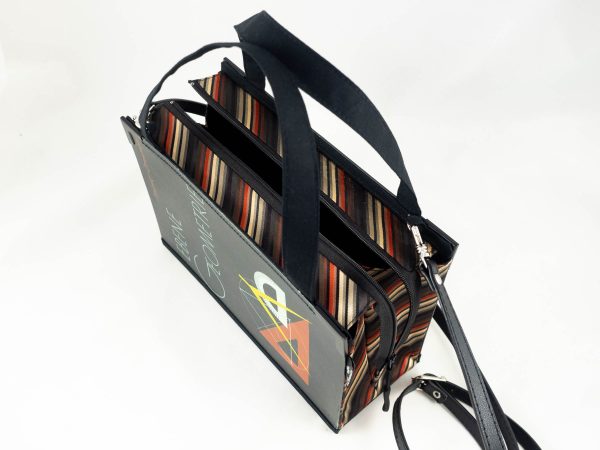 Tasche aus einem Geometrie-Lehrbuch in Schwarz mit Lineal und Zirkel am Cover kombiniert mit schwarz/gelb/orange gestreifter Krawatte