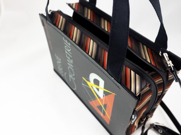Tasche aus einem Geometrie-Lehrbuch in Schwarz mit Lineal und Zirkel am Cover kombiniert mit schwarz/gelb/orange gestreifter Krawatte