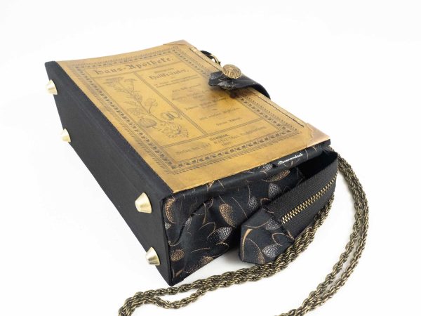 Tasche aus einem alten, abgenutzten Buch "Heilkräuter" der Serie Haus-Apotheke, braun mit schwarzer Aufschrift, Bild und Ornamenten, kombiniert mit schwarz/brauner Blätterkrawatte und schwarzem Stoff