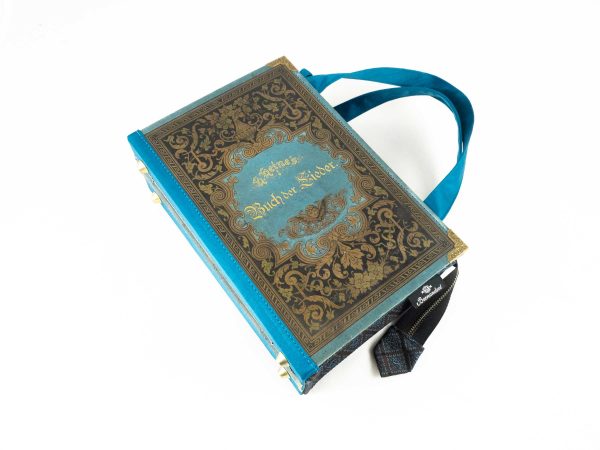 Tasche aus einem Buch von Heine "Buch der Lieder" in hellblau/petrol gehalten mit goldenen Ornamenten am Cover kombiniert mit braun/petrol gemusterter Krawatte und petrolfarbenem Stoff