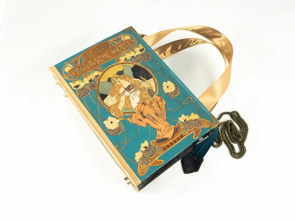 Tasche aus einem Buch "Heines prosaische Werke" mit wunderschön geprägter Illustration am Cover, Hintergrundfarbe türkies, kombiniert mit braun/blau gemusterter Paisley-Krawatte und goldenen Stoffkombinationen