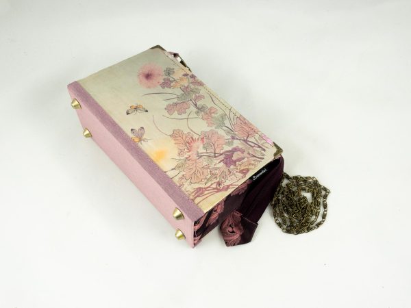 Taschen aus einem Buch von Pearl S. Buck mit rosa/lila Blumen am Cover, kombiniert mit rosa/lila schimmernder Krawatte