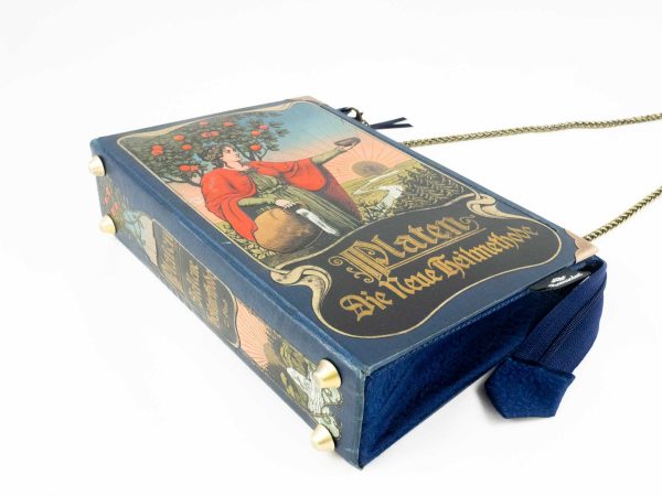 Tasche/Clutch aus einem blauem PLATEN Buch, mit mystische illuistrierten Prägungen am Cover, farbenreich, kombiniert mit blauer Krawatte