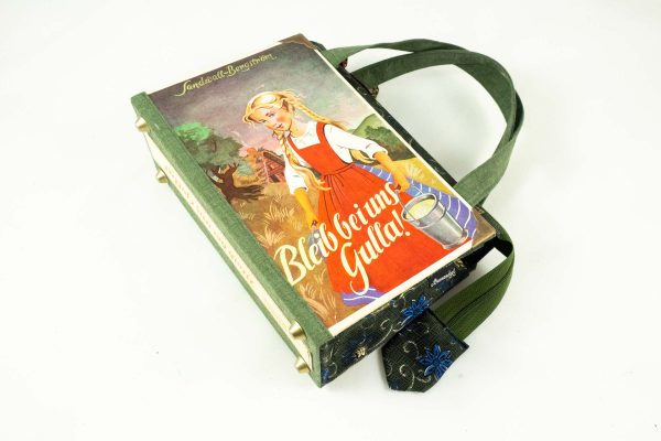 Tasche aus einem Gulla Kinderbuch in rot, grün und blau gehalten. Gulla am Cover mit Milcheimer und er Hand, kombiniert mit einer grün/blau blumigen Krawatte