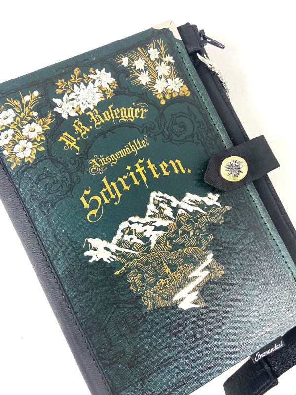 Tasche aus einem Peter Rosegger Buch in dunkelgrün mit Bergen und Edelweiß am Cover, Schwarz-, Gold- und Silberprägungen