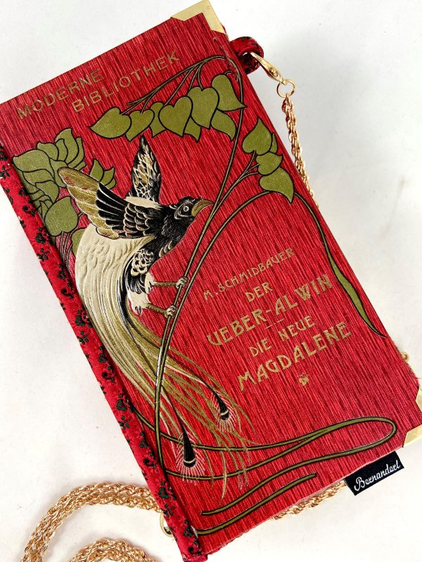 Tasche/Clutch aus einem kleinen Büchlein der Serie "Moderne Bibliothek" in rot, am Cover ein großer prächtiger Vogel, schön geprägtes Cover mit Titel "Der Über-Alvin" und " Die neue Magdalene", kombiniert mit einer roten Trachtenkrawatte passend zum Cover.
