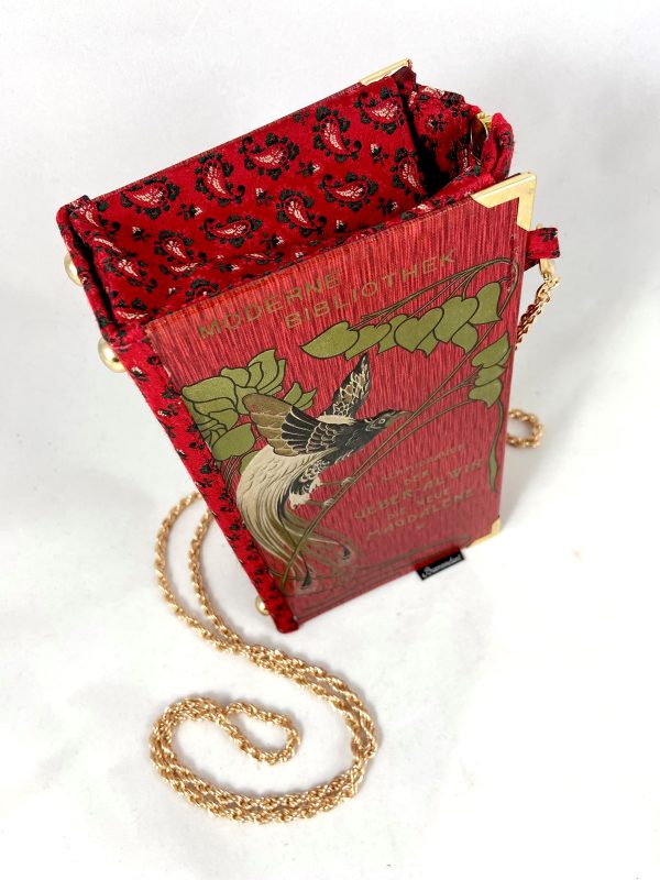 Tasche/Clutch aus einem kleinen Büchlein der Serie "Moderne Bibliothek" in rot, am Cover ein großer prächtiger Vogel, schön geprägtes Cover mit Titel "Der Über-Alvin" und " Die neue Magdalene", kombiniert mit einer roten Trachtenkrawatte passend zum Cover.