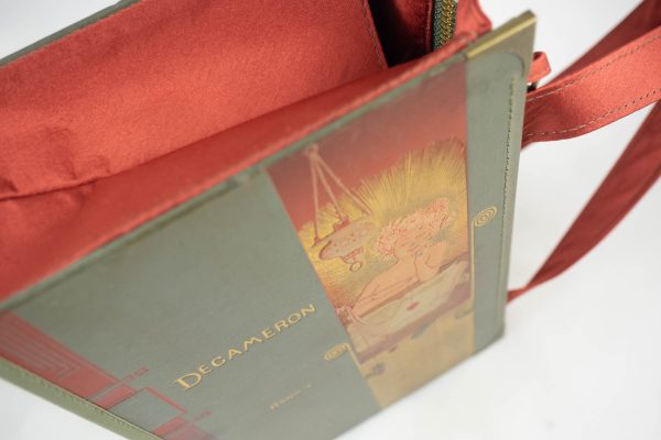 Tasche aus einem Buch von Boccaccio's Decameron im grauen Cover mit eine Dame drauf, die ein Herz über einem Buch baumeln läasst. Goldelemente und dunkelorange, kombiniert mit einer dunkelorangen Krawatte