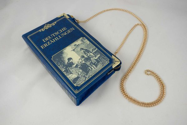 Tasche aus einem Buch "Deutsche Erzählungen" in Blau mit einem alten Bild am Cover, das eine Szene aus dem früheren Leben zeigt,kombiniert mit blauer Krawatte