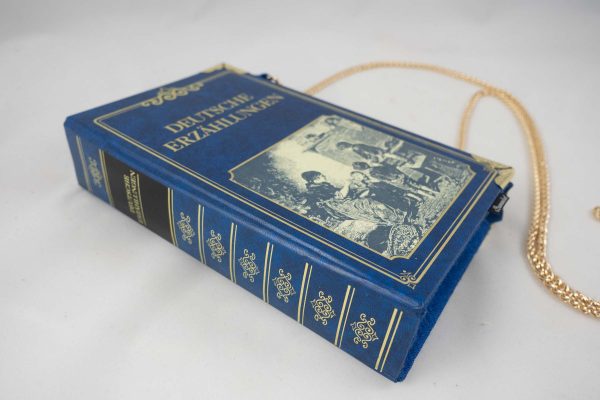 Tasche aus einem Buch "Deutsche Erzählungen" in Blau mit einem alten Bild am Cover, das eine Szene aus dem früheren Leben zeigt,kombiniert mit blauer Krawatte