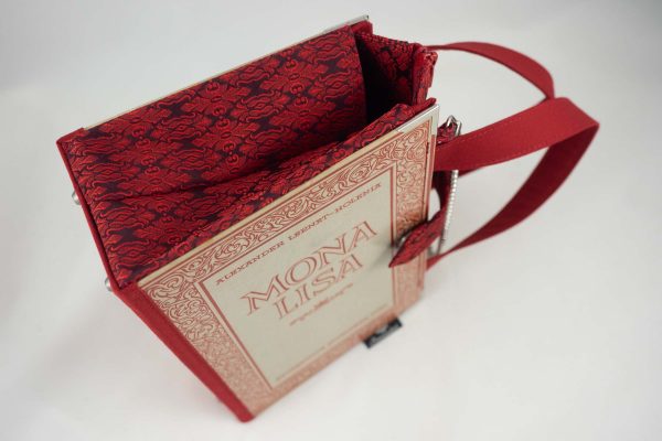 Tasche aus einem Buch "Mona Lisa" mit schönen roten Verzierungen rundum, kombiniert mit einer rot gemusterten Krawatte